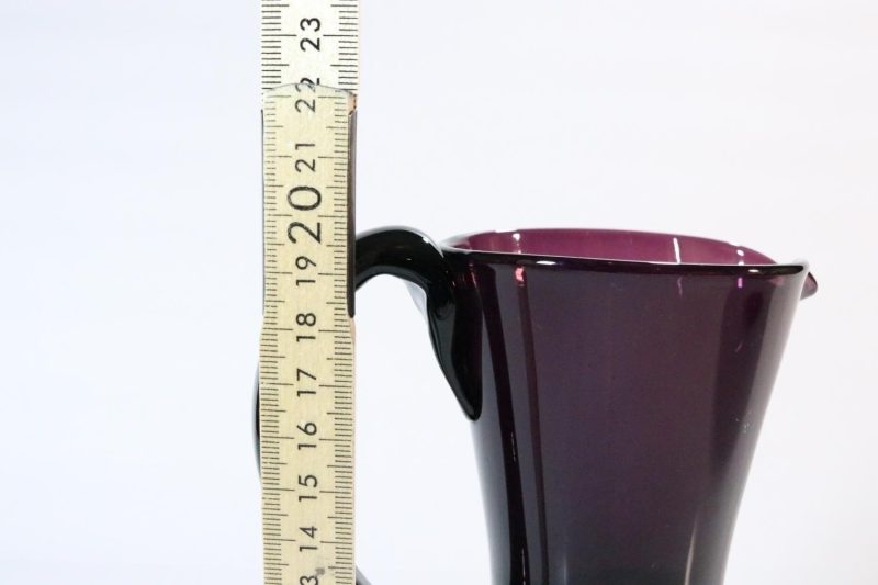 Kanna, llila glas med intryckta sidor