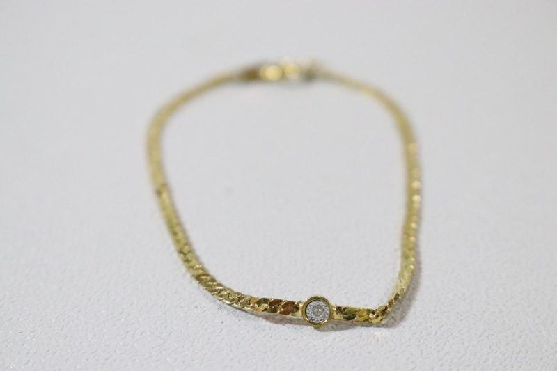 Stilrent guldfärgat armband med sten på