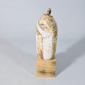 Liten skulptur i form av ett ansikte på träsockel, osignerad, lagad