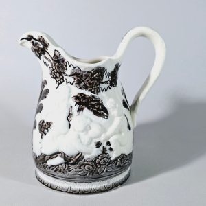 Kanna, llila glas med intryckta sidor