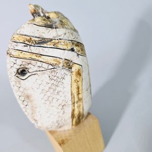 Liten skulptur i form av ett ansikte på träsockel, osignerad, lagad