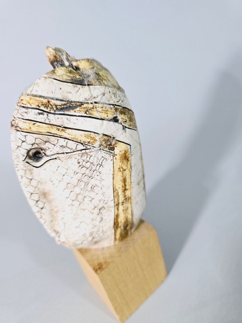 Liten skulptur i form av ett ansikte på träsockel, osignerad, lagad