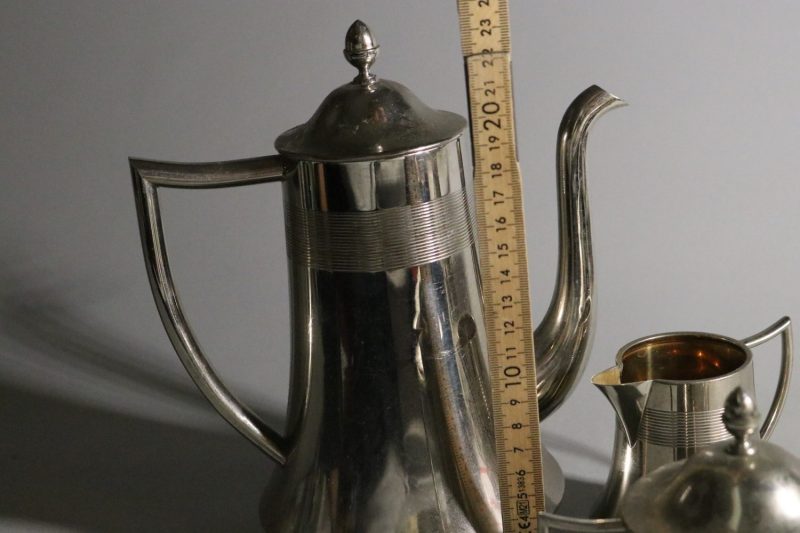 Elegant kaffekanna med tillhörande gräddkanna och sockerskål i nysilver