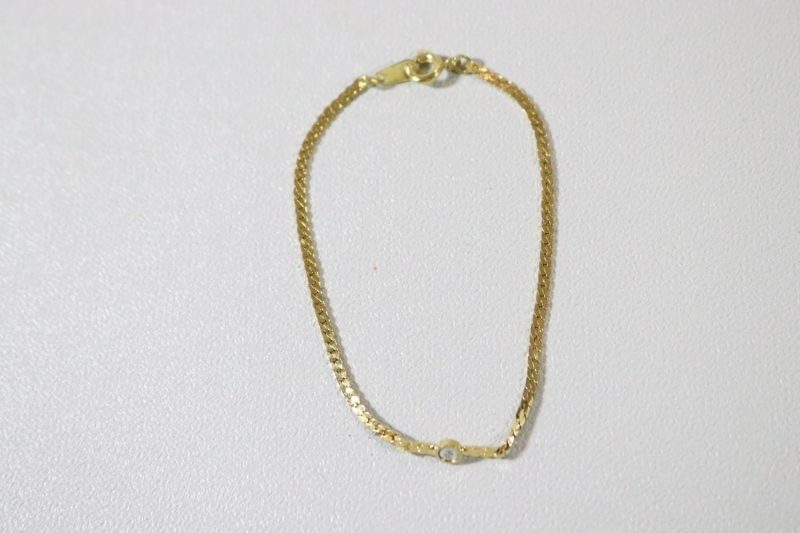 Stilrent guldfärgat armband med sten på