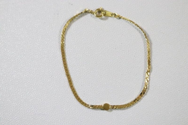 Stilrent guldfärgat armband med sten på