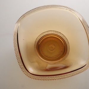 Gyllene färgad glasskål med en dekorativ kant