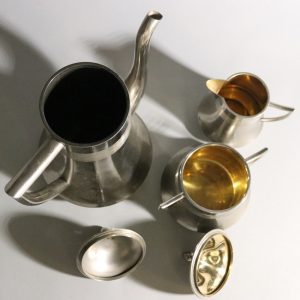 Elegant kaffekanna med tillhörande gräddkanna och sockerskål i nysilver