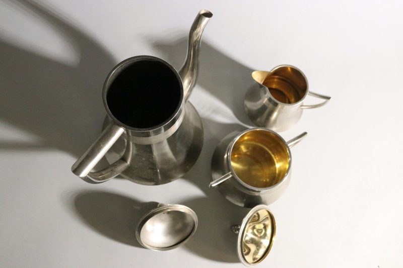 Elegant kaffekanna med tillhörande gräddkanna och sockerskål i nysilver