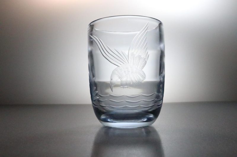 Vas i blåtonat glas, graverad med en fågel, troligen Hovmantorp nya glasbruk