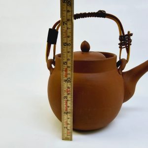 Traditionell terrakottatekanna med handtag och sil