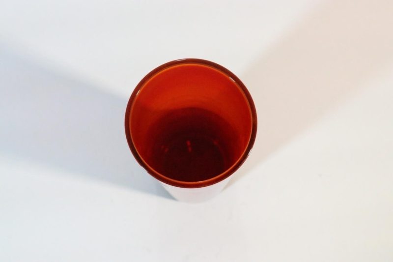 Cylinderformad glasvas, röd övergående mot orange/gul på mynningen