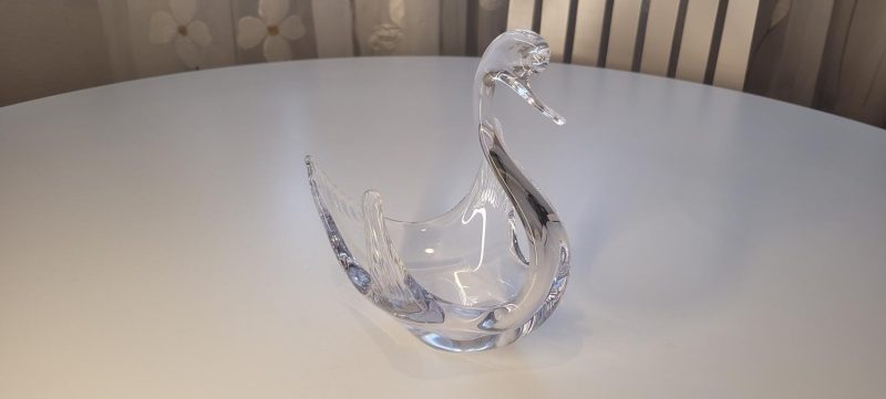 Svan i glas med uppspärrade vingar och vackert krökt hals