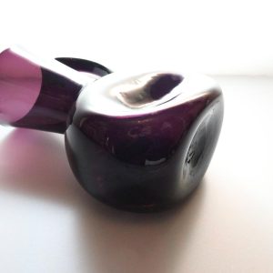 Kanna, llila glas med intryckta sidor