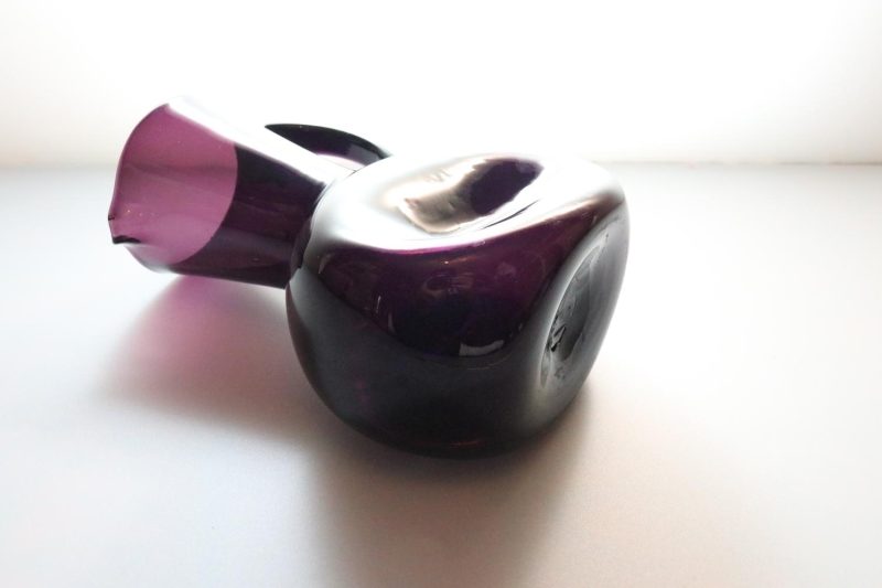 Kanna, llila glas med intryckta sidor