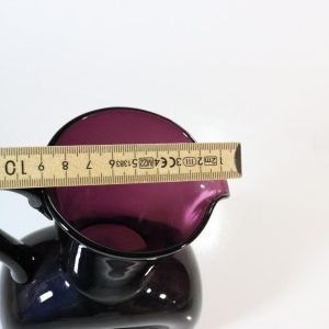 Kanna, llila glas med intryckta sidor