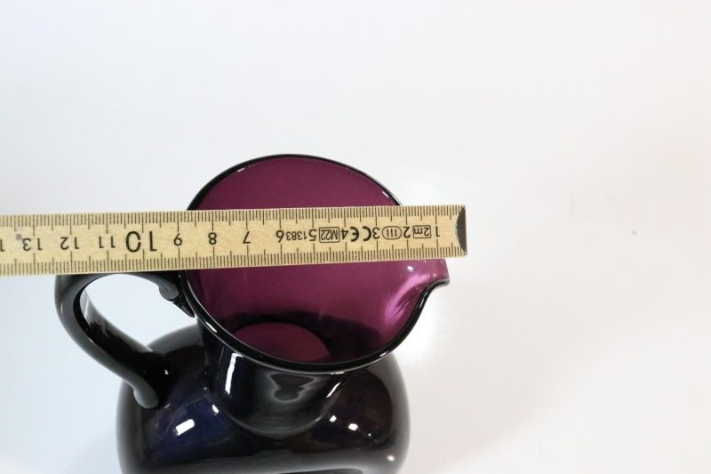 Kanna, llila glas med intryckta sidor
