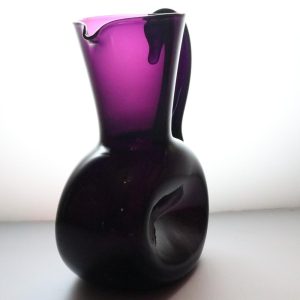 Kanna, llila glas med intryckta sidor