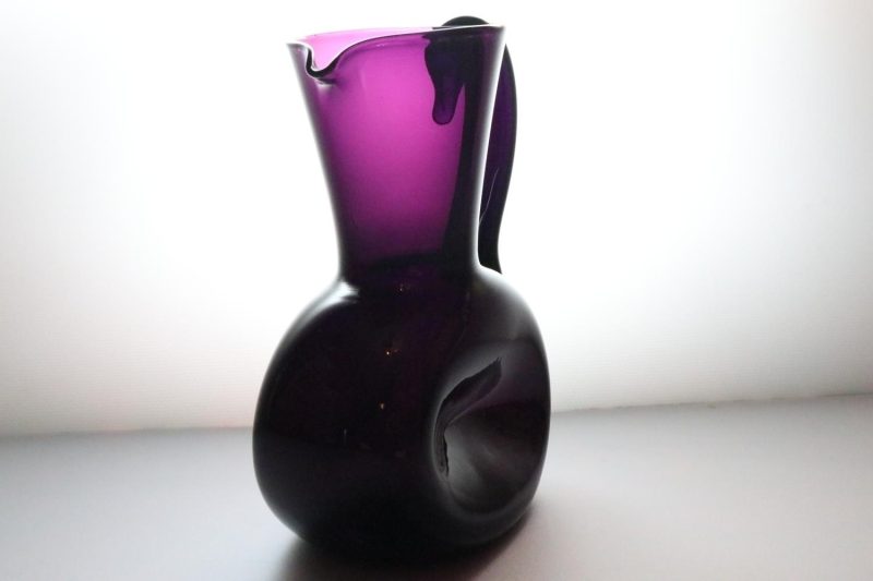 Kanna, llila glas med intryckta sidor