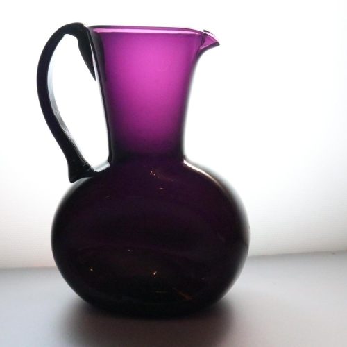 Kanna, llila glas med intryckta sidor