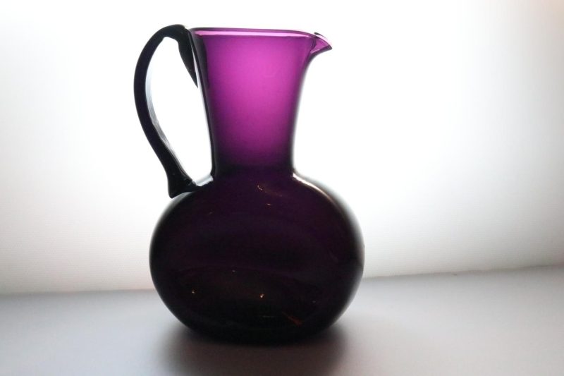 Kanna, llila glas med intryckta sidor