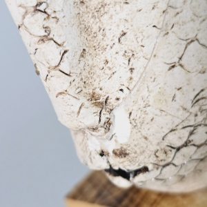 Liten skulptur i form av ett ansikte på träsockel, osignerad, lagad