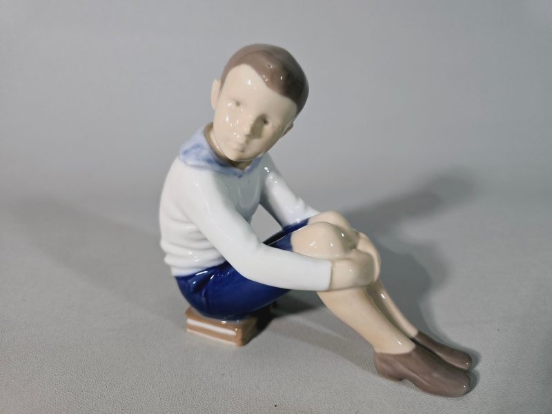 Figurin,  Bing & Gröndahl Pojke sittandes på en bok nr 1742