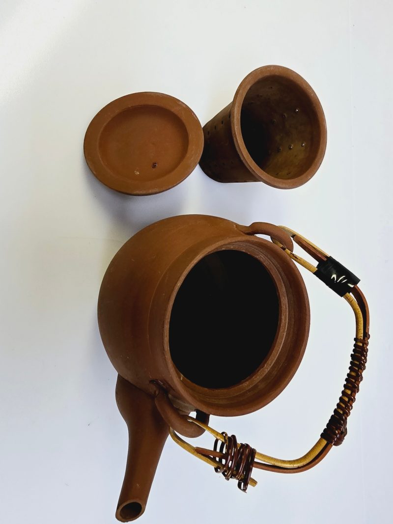 Traditionell terrakottatekanna med handtag och sil