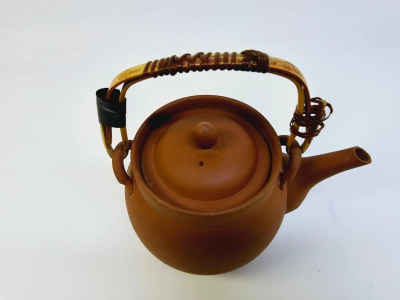 Traditionell terrakottatekanna med handtag och sil