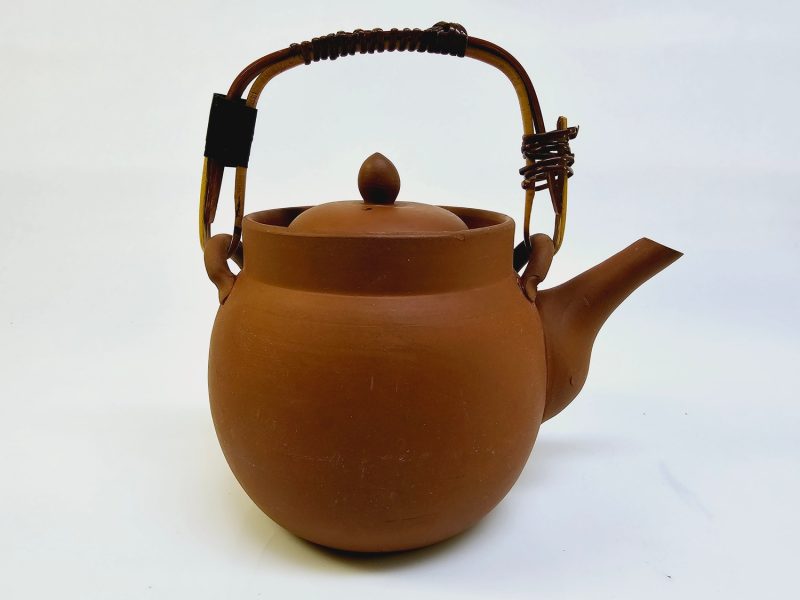 Traditionell terrakottatekanna med handtag och sil