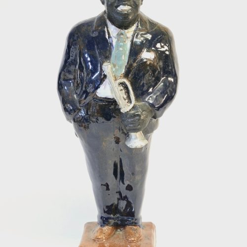 En unik keramikfigur föreställande en musiker med trumpet, tillverkad och signer