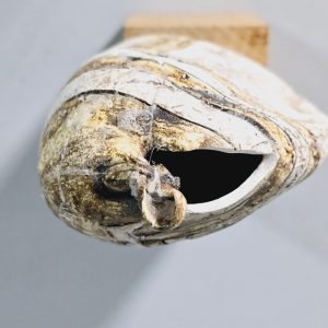 Liten skulptur i form av ett ansikte på träsockel, osignerad, lagad