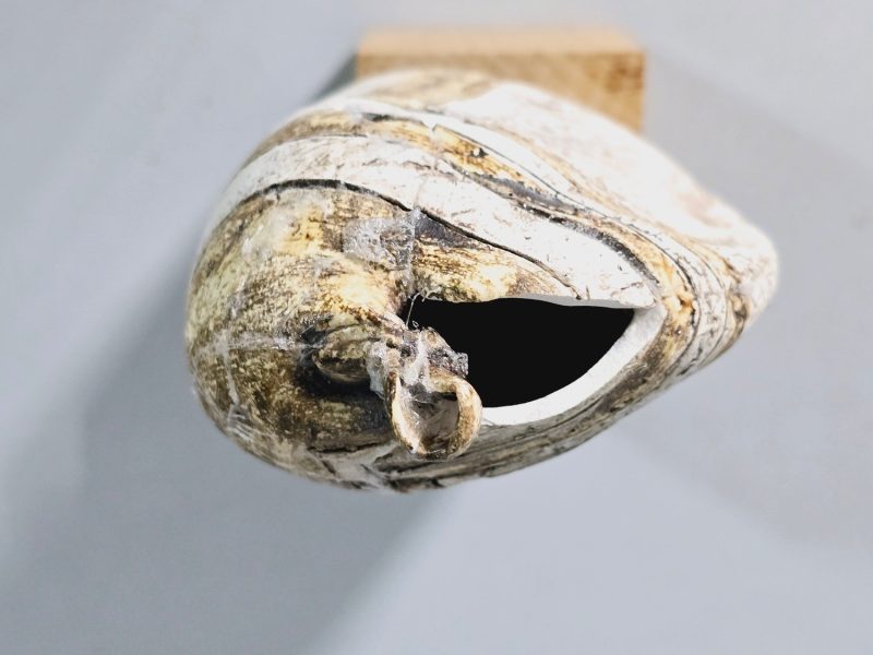 Liten skulptur i form av ett ansikte på träsockel, osignerad, lagad