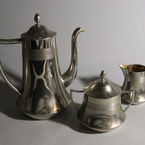 Elegant kaffekanna med tillhörande gräddkanna och sockerskål i nysilver