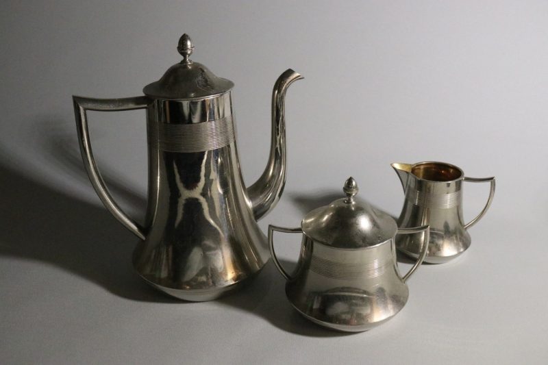 Elegant kaffekanna med tillhörande gräddkanna och sockerskål i nysilver