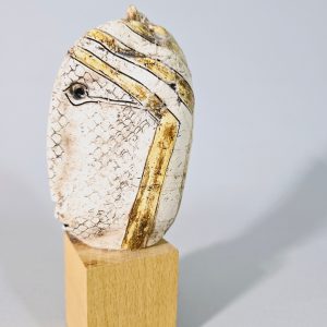 Liten skulptur i form av ett ansikte på träsockel, osignerad, lagad