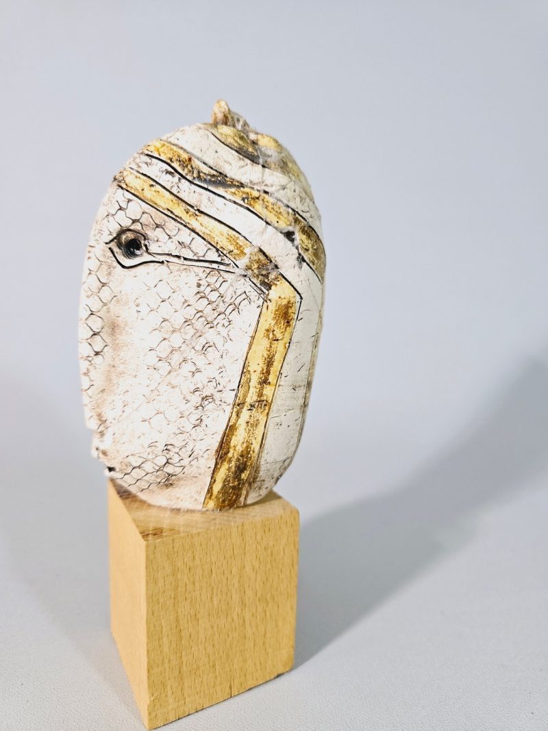 Liten skulptur i form av ett ansikte på träsockel, osignerad, lagad